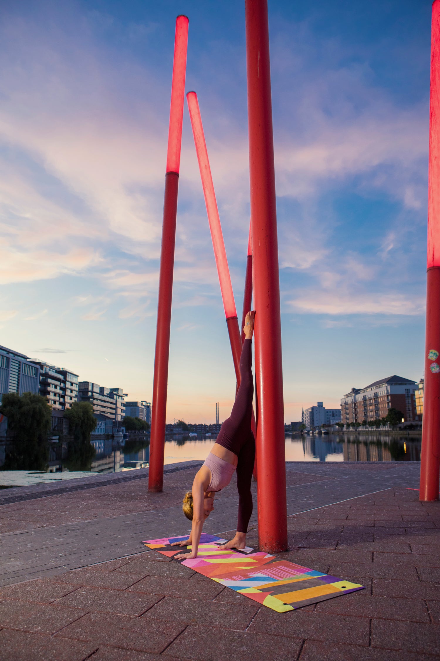 A woman practicing yoga on a Flowstate yoga mat beside a canal