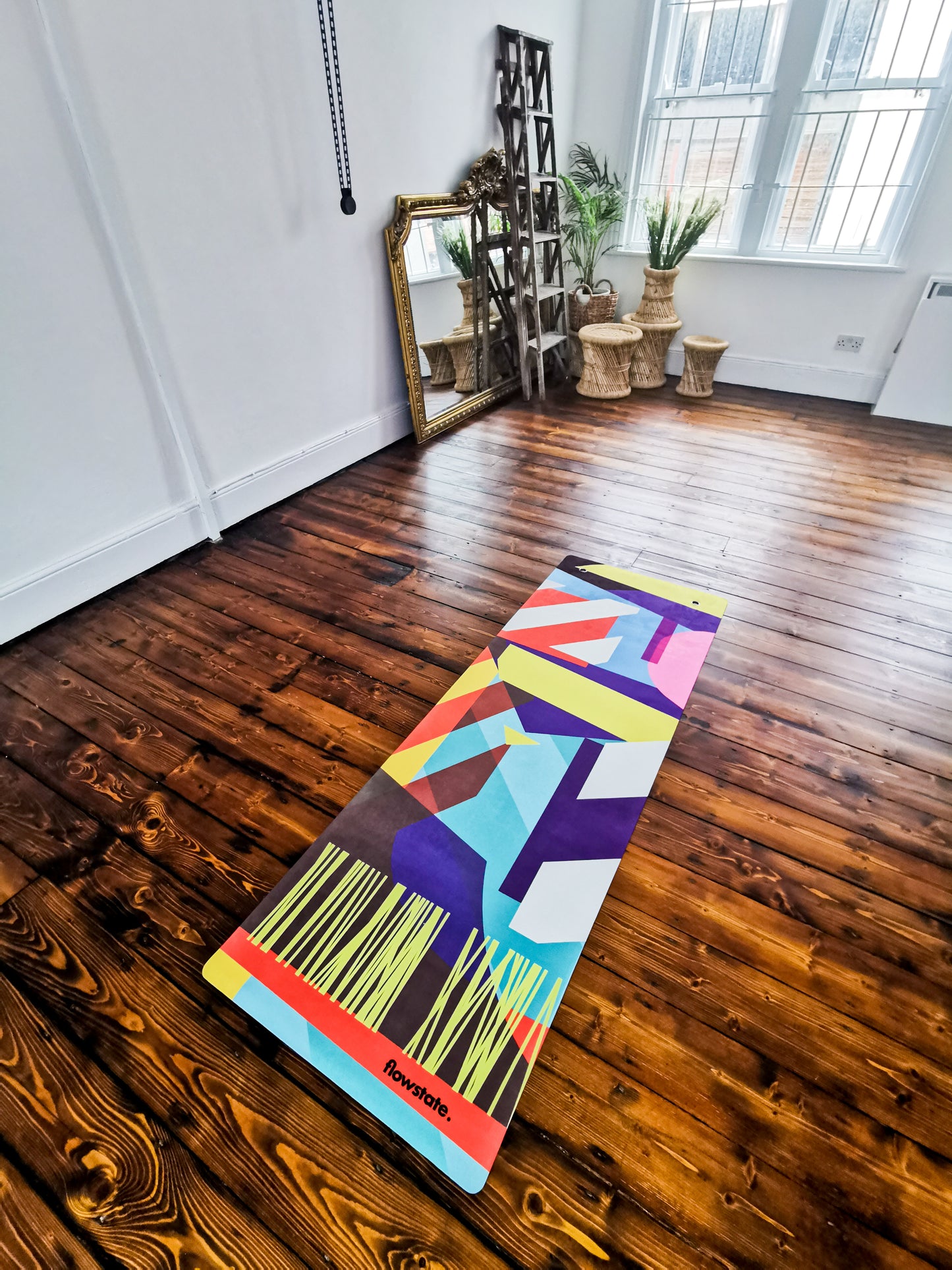 The Equilibrium 2 Flowstate Yoga Mat in an empty room